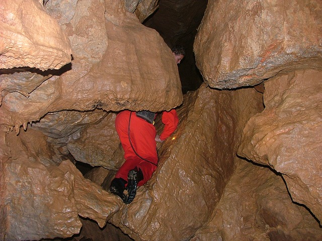 Caver squeezes through a tight gap in a pothole