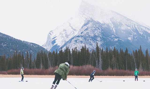 Playing ice hockey outdoors on a lake with the mountains in the background