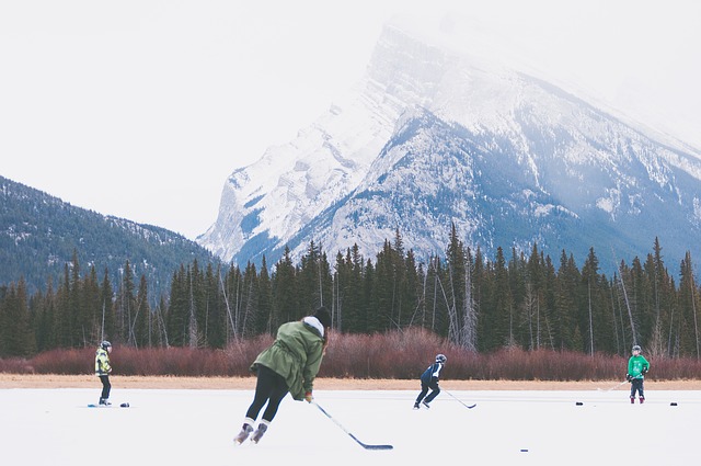 Playing ice hockey outdoors on a lake with the mountains in the background