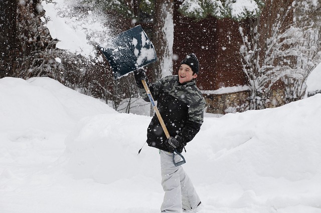 Boy clearing snow with a snow shovel