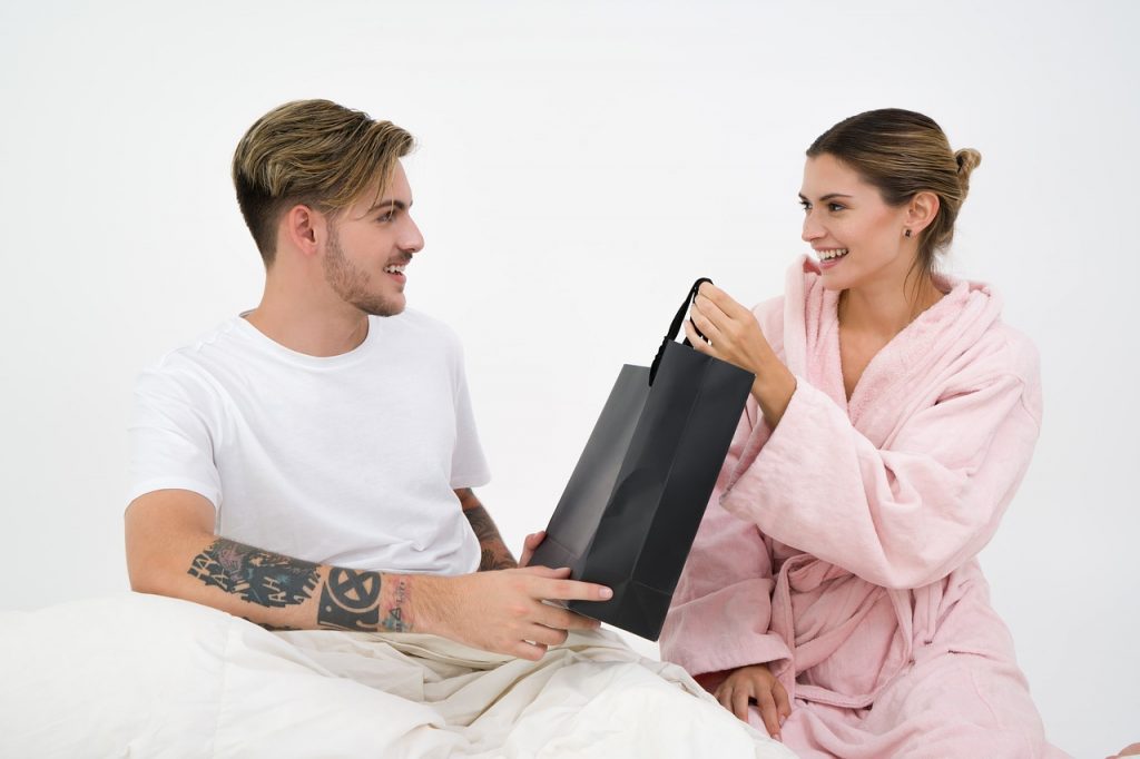 woman giving her boyfriend a gift present